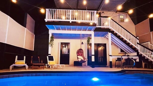 A two-story building with a pool, outdoor seating, and a staircase. - ⛱  Spacious, Private Pool, Golf Cart - just RELAX  🏝 (Panama City Beach)
