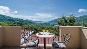 A balcony with a table and chairs, overlooking a mountainous landscape. - Pool Villa Panorama Mojdez /w Sea View (Mojdez)