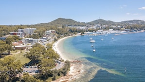Un pueblo costero con playa, barcos y edificios.