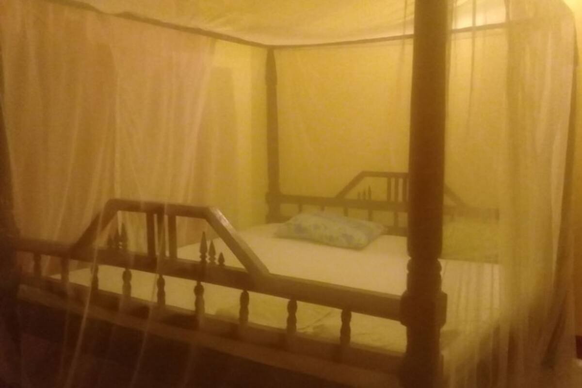 A bed with a wooden frame and a canopy.