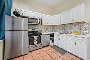 A modern kitchen with white cabinets, stainless steel appliances, and patterned backsplash tiles. - Stunning 3 BR in prime Chicago location (Chicago)