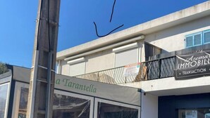 En butik med et skilt der siger "Azema Immobilier Transaction" og en hvid markise med navnet "La Tarantella".