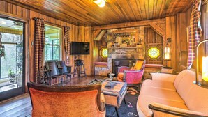 A cozy cabin interior with a wooden ceiling, a fireplace, a television, and comfortable seating. - Dreamy Homestead Escape: Patio, Ranch On-Site (Crossville)