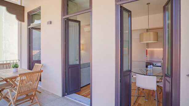 A modern apartment with a dining area, a kitchen, and a balcony. - Feel Porto Matosinhos Ocean Flat III (Matosinhos)