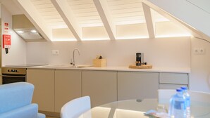 A modern kitchen with a skylight, a coffee maker, and a water bottle on the counter. - Feel Porto Matosinhos Ocean Flat IV (Matosinhos)