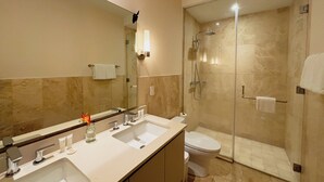 Un bagno moderno con due lavandini, un water, una doccia e uno specchio grande.