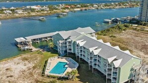 A coastal hotel with multiple balconies, a swimming pool, and a marina. - Jubilee Landing 303 | Boaters Welcome | Outdoor Pool | My Beach Getaways (Orange Beach)