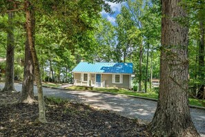 A small house with a blue roof, surrounded by trees.