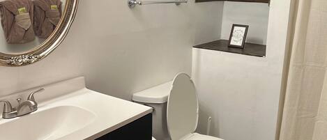 Tina con regadera, toallas, jabón, papel de baño
