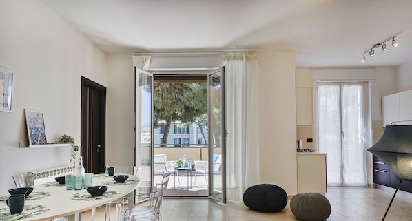 A modern kitchen with a dining area, a view of the outdoors, and a 'smart working' sign.