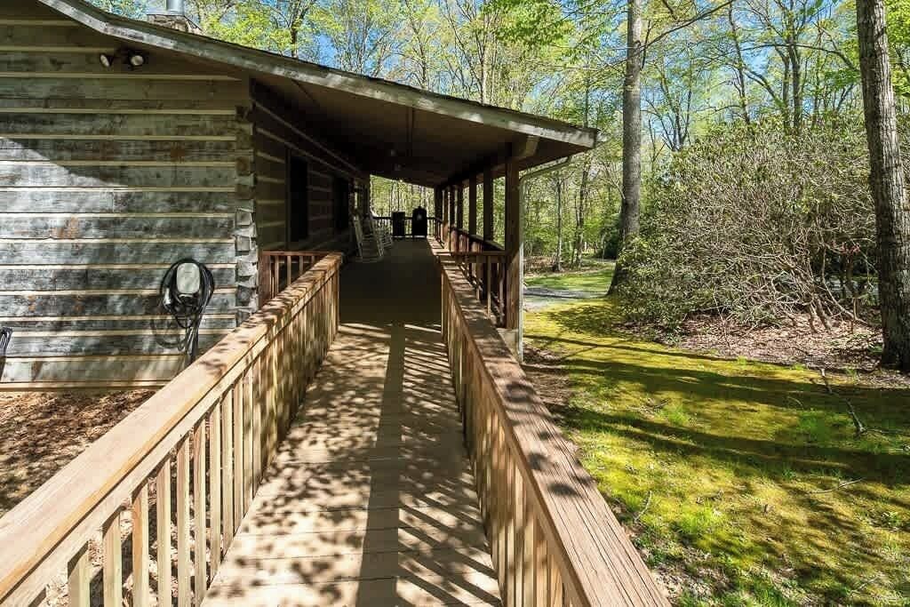 Eine Blockhütte mit überdachter Veranda und einem hölzernen Weg, der dorthin führt.