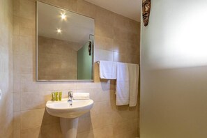 Ein Badezimmer mit Waschbecken, Spiegel und zwei Handtüchern, die an der Wand hängen.