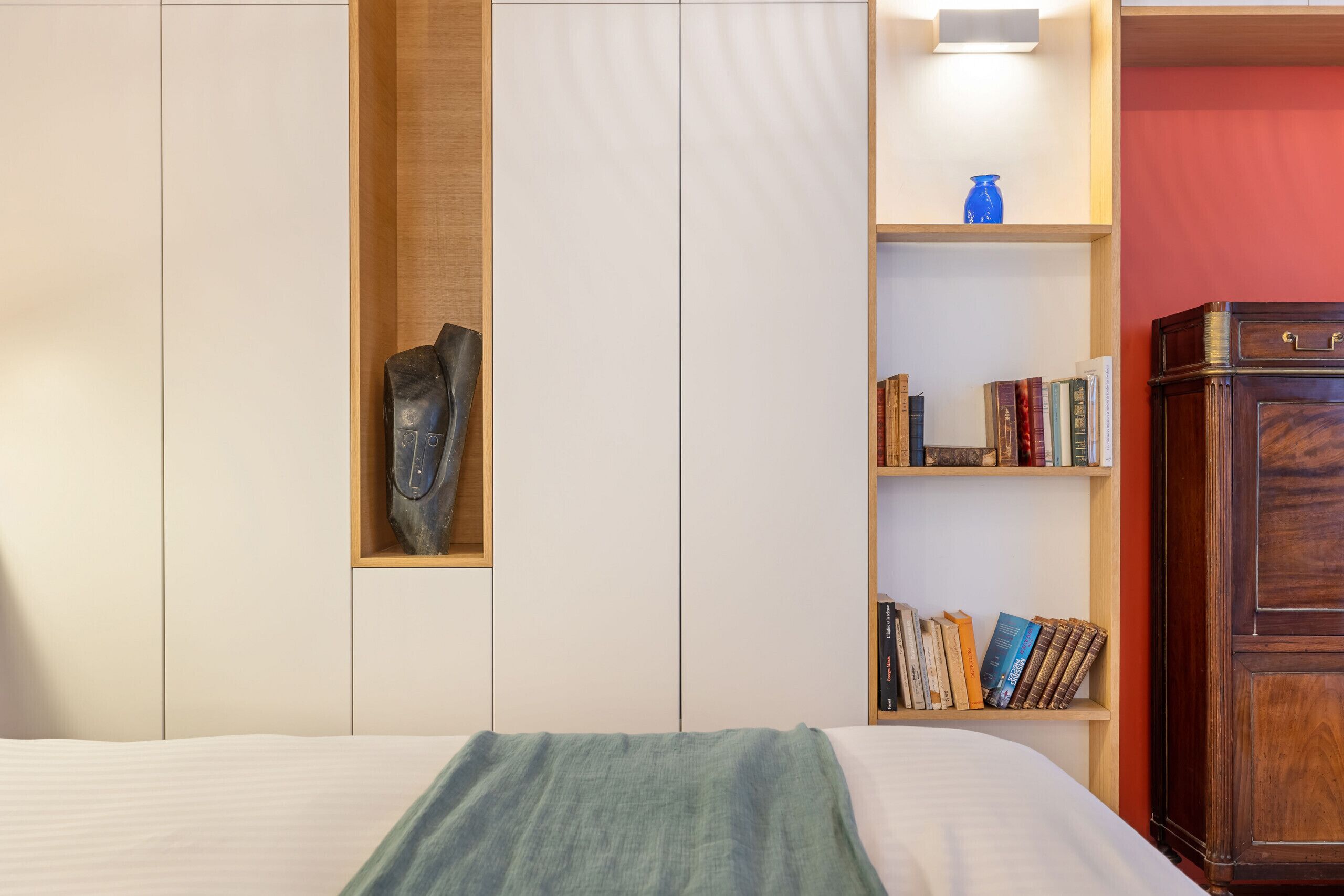 Ein Schlafzimmer mit einem Bett, einem Bücherregal und einem Kleiderschrank.