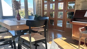 A dining area with a wooden table, chairs, and a piano.