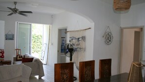 A dining area with a table, chairs, and a ceiling fan.
