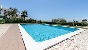 Una piscina rectangular con un borde empedrado y agua azul cristalina.