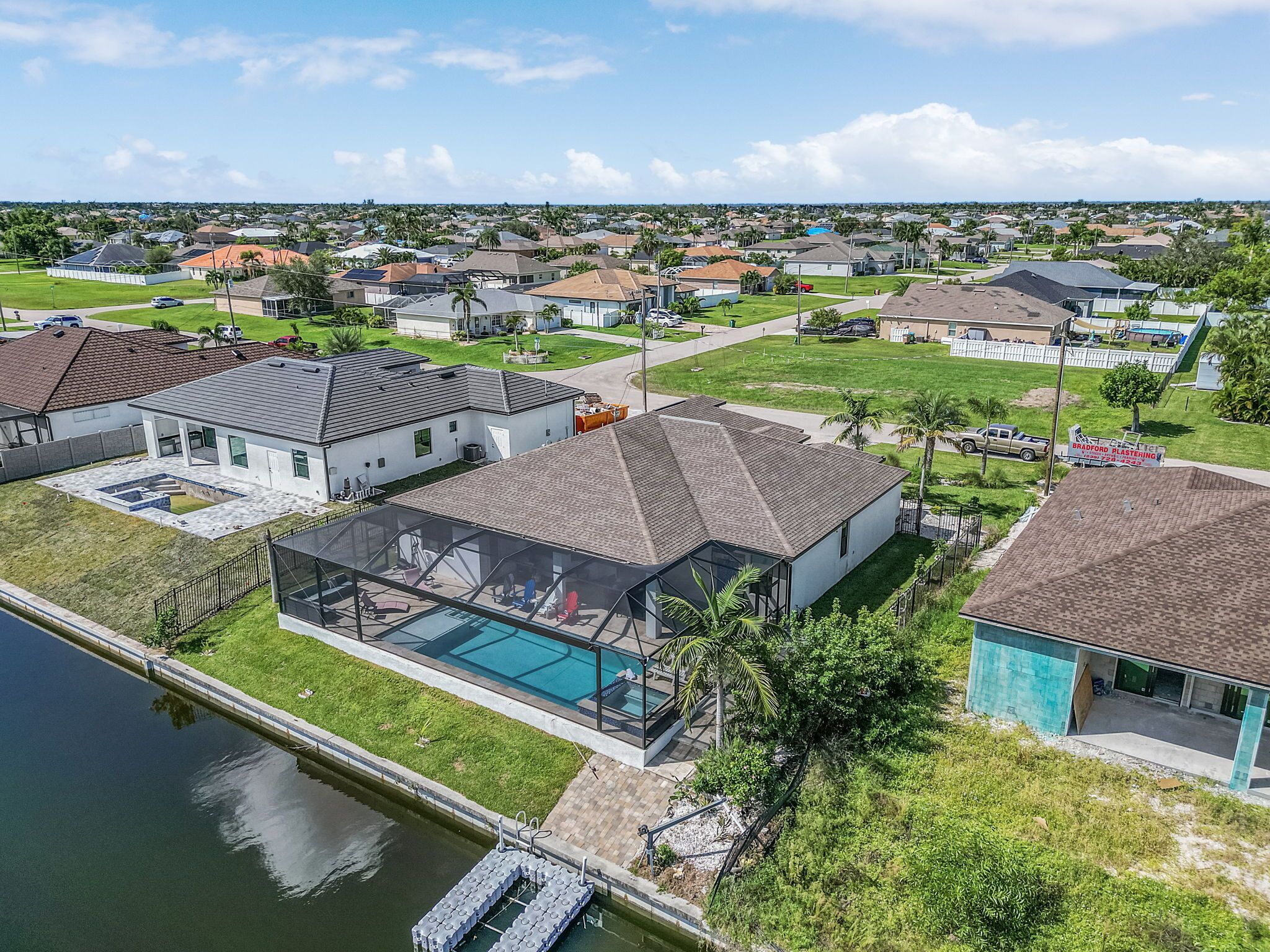 A residential area with houses, a swimming pool, and a dock.