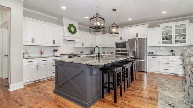 A modern kitchen with white cabinets, a large island, stainless steel appliances, and pendant lighting. - Perfect Masters Rental in Golf Course Community - Bartram Trail CC: Augusta, GA  (Evans)