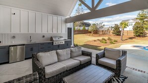 An outdoor patio with a grill, wicker furniture, and a view of the backyard. - Perfect Masters Rental in Golf Course Community - Bartram Trail CC: Augusta, GA  (Evans)