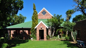 A brick building with a green roof and a triangular window. - - Country getaway in Peaceful setting yet minutes from Town (Gqeberha)