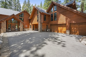A large, multi-story log cabin with a stone foundation, large windows, and a garage. - Spectacular low elevation home at its finest! (Incline Village)