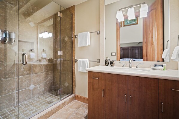 A modern bathroom with a glass-enclosed shower, a vanity with a sink, and a large mirror. - 5BR Incline Village Retreat | Hot Tub & Mountain Views (Incline Village)