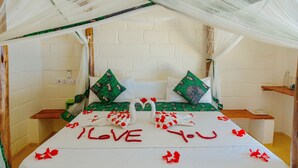 A bed with a canopy, pillows, and a bedspread with "I LOVE YOU" written on it. - Tropicana Garden (Kendwa)