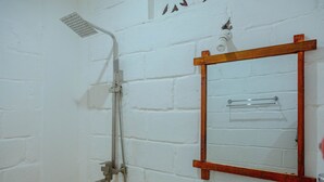 A bathroom with a shower, a wooden bench, a mirror, and a towel rack. - Tropicana Garden (Kendwa)