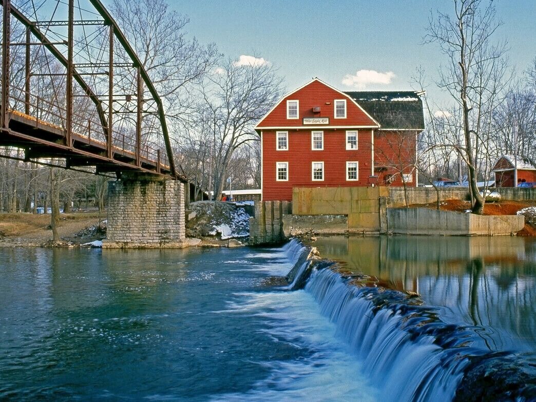 Un edificio rojo con un letrero, un puente y un canal de agua.