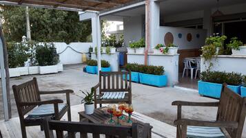 Relax in a serene outdoor space with a pergola, comfortable seating, and lush greenery.