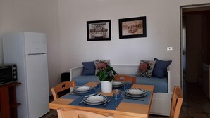 Un espacio habitable compacto con comedor, kitchenette y sofá.