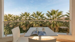Un balcon avec une table, un livre, une tasse et une théière.