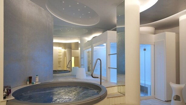 Un spa moderne doté d’un jacuzzi, de revêtements de sol en bois et d’un design minimaliste.