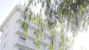 A modern building with a pool area, featuring a tiled deck and a palm tree. - Residenza Excelsior 704 (Vasto)