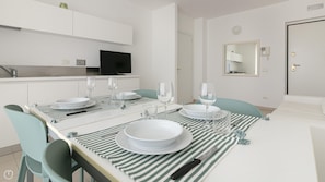 A modern dining area with a white table set for two, striped placemats, and matching chairs. - Residenza Excelsior 701 (Vasto)