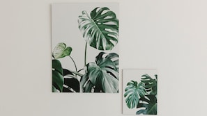 A wall with a large framed botanical print featuring tropical leaves. - Residenza Excelsior 701 (Vasto)