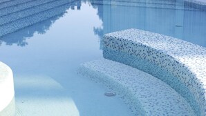 A clear swimming pool with a tiled edge and steps leading into the water. - Residenza Excelsior 606 (Vasto)