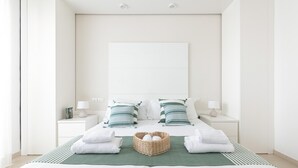 A minimalist hotel room with a large bed, two bedside tables, and a green throw blanket. - Residenza Excelsior 606 (Vasto)