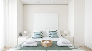 Camera d'albergo dal design minimalista, con un letto grande, due comodini e una coperta verde.