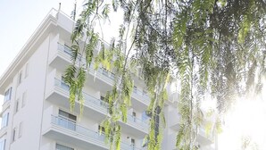 A modern building with a pool area, featuring a tiled deck and a palm tree. - Residenza Excelsior 603 (Vasto)