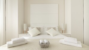 A minimalist bedroom with a large bed, two bedside lamps, and a bedside table with a lamp. - Residenza Excelsior 902 (Vasto)