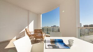 A balcony with a white table, two wicker chairs, a magazine, and a white mug. - Residenza Excelsior 902 (Vasto)