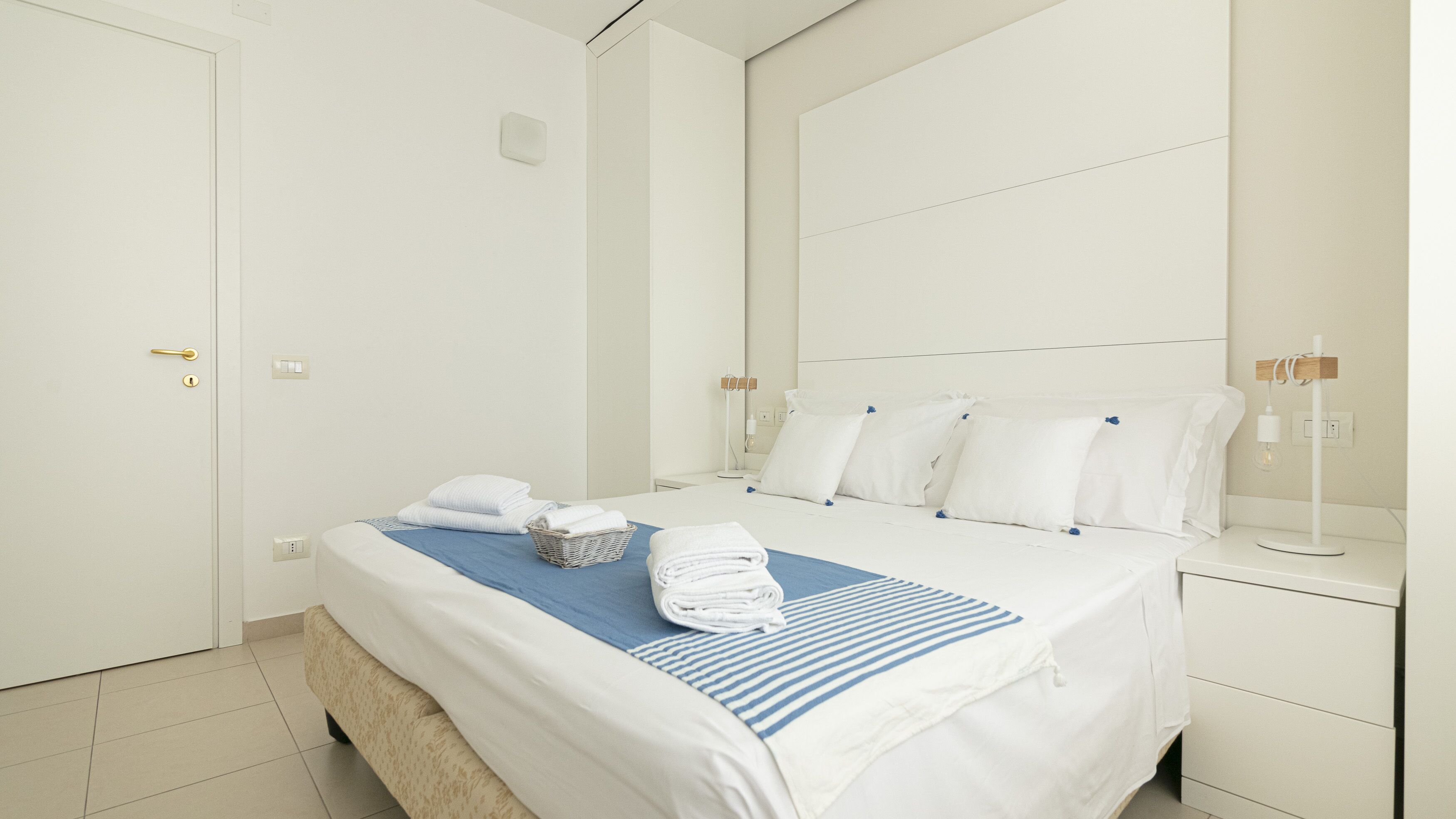 Ein Hotelzimmer mit einem Bett, einem Nachttisch und einem wandmontierten Spiegel.