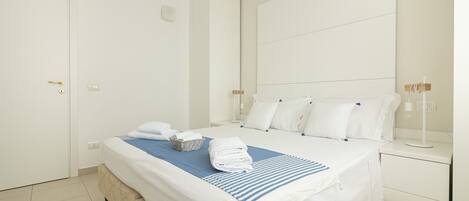 Ein Hotelzimmer mit einem Bett, einem Nachttisch und einem wandmontierten Spiegel.