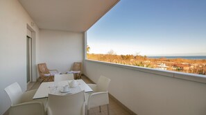 Ein Balkon mit Tisch, Stühlen und Blick auf eine weite Landschaft.