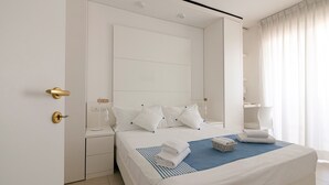 Ein modernes Hotelzimmer mit einem großen Bett, einem Nachttisch und einem Spiegel.