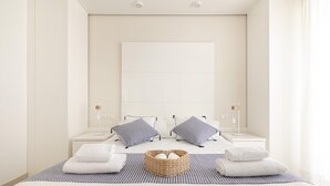 Une chambre à coucher moderne avec un grand lit, deux tables de chevet et une tête de lit.