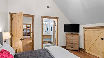 Une chambre à coucher comprenant un lit, une télévision, une commode et une armoire.