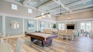 A spacious room with a pool table, dining area, and a television. - Cool Coastal Condo #1144 with Sunset Views at Cinnamon Beach (Palm Coast)
