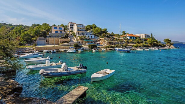 A coastal village with boats docked at a pier, buildings on a hillside, and clear blue water. - Goreta in Ražanj - Mittel-Dalmatien / Goreta in Ražanj - Appartement für 4 Personen AP2 (Ražanj)